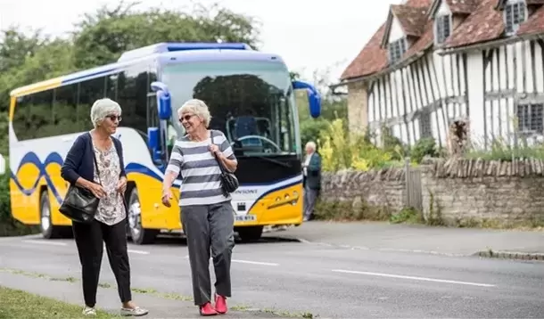 Two women walking by Johnsons coach